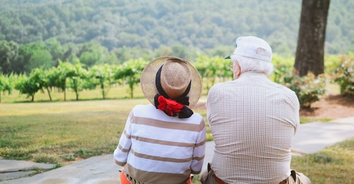 Two seniors sitting in front of a mountain