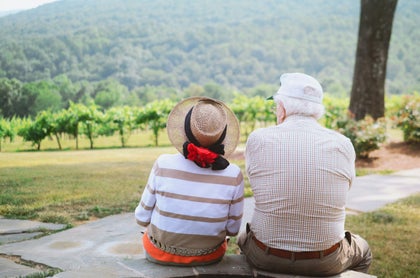 Two seniors sitting in front of a mountain