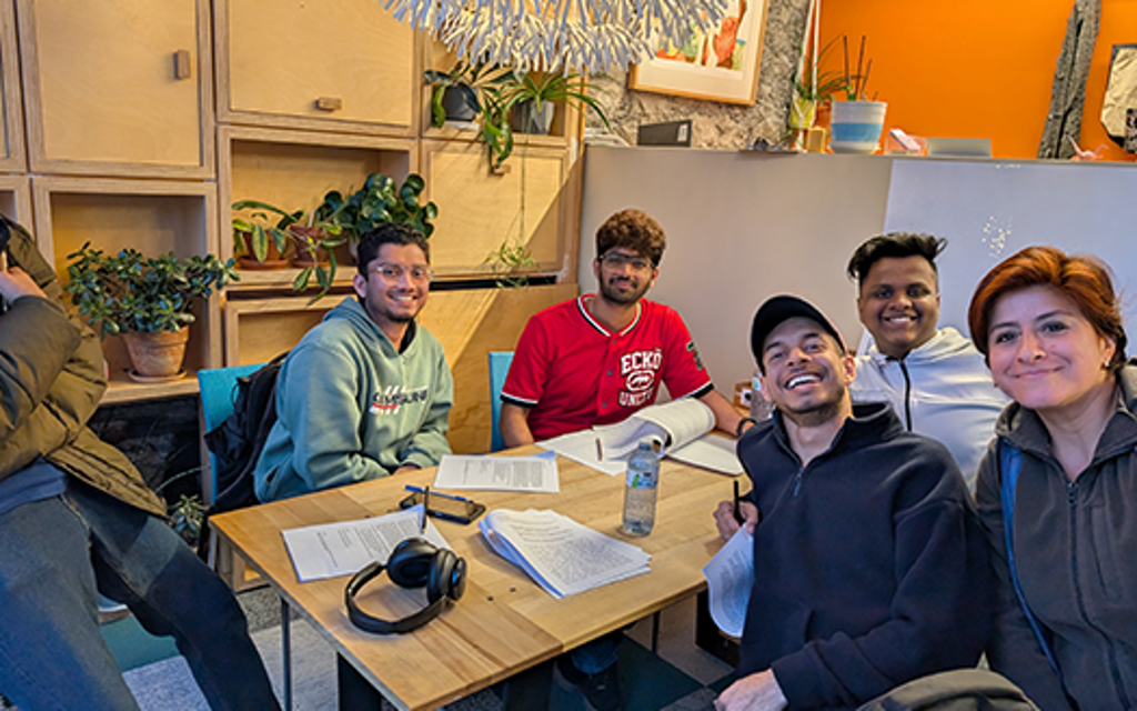 Students around a table smiling