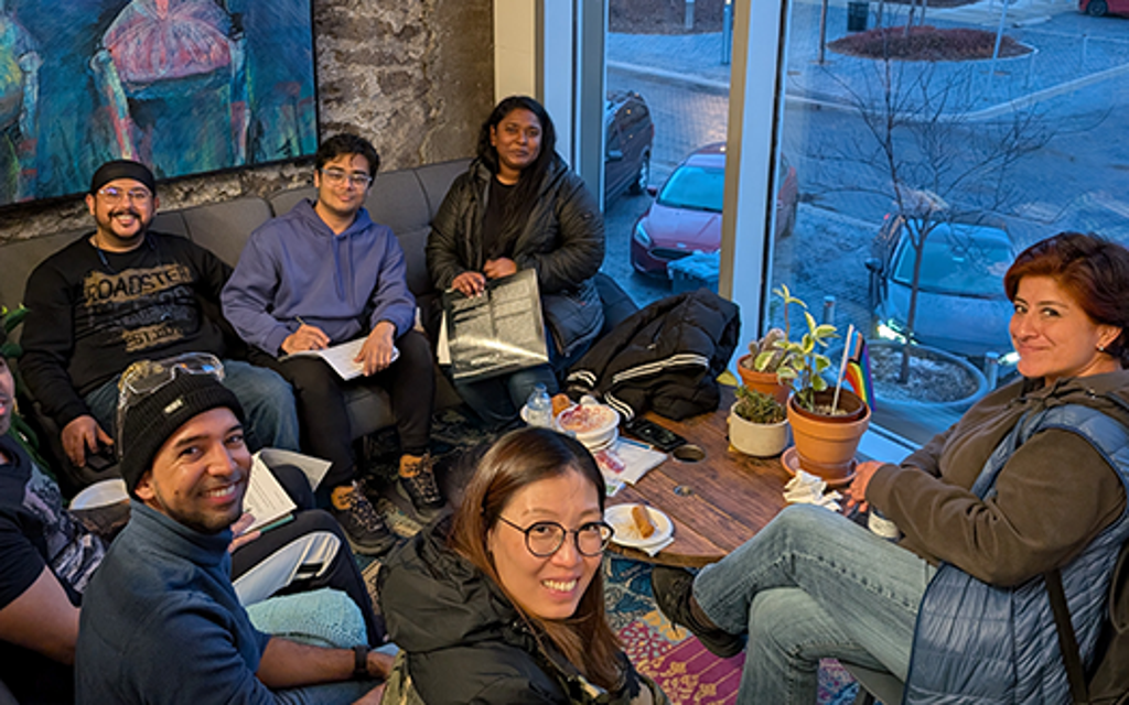Students around a table smiling