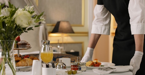 a server setting a table setting at a restaurant 