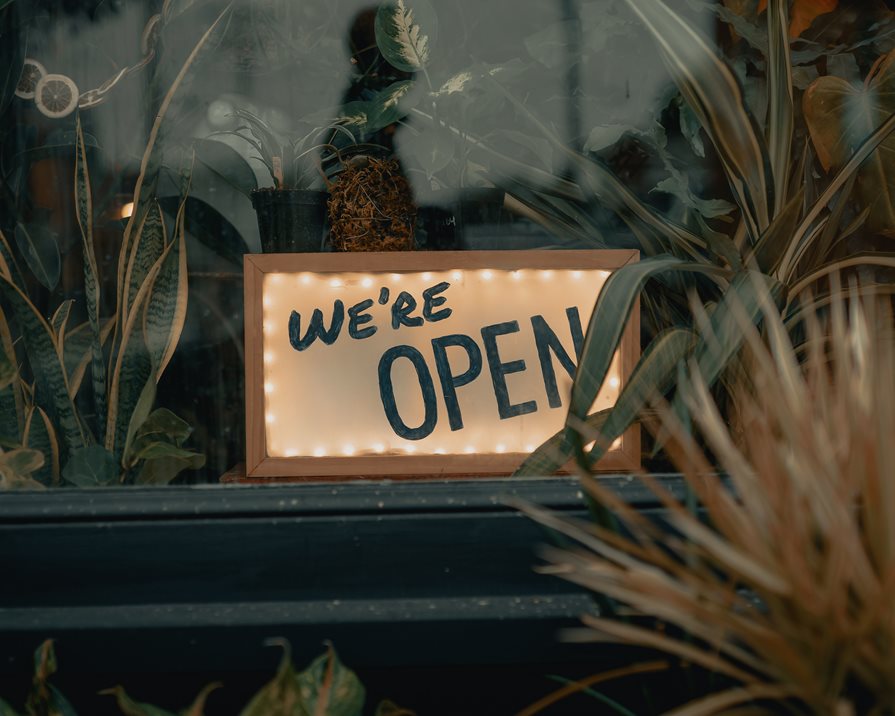 A sign on a storefront saying "we're open"