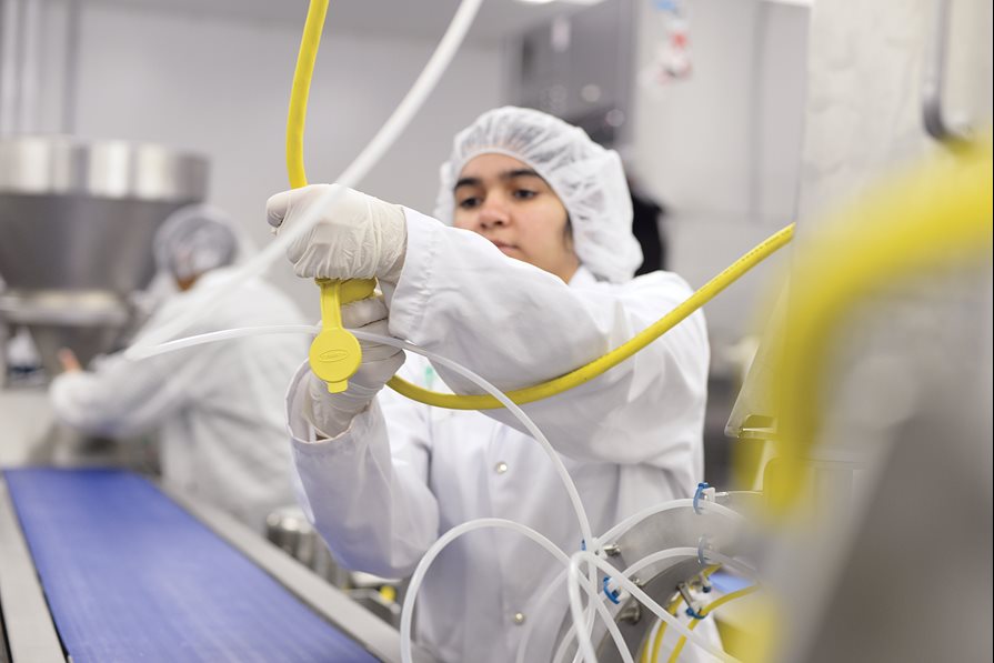 A food service worker using a machine