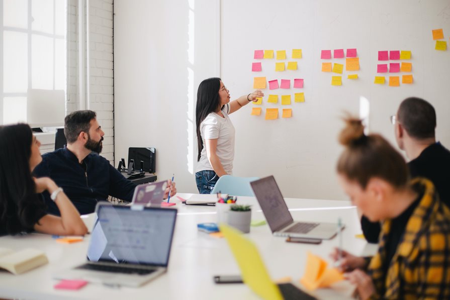 A group of people collaborating in a meeting room A group of people collaborating in a meeting room