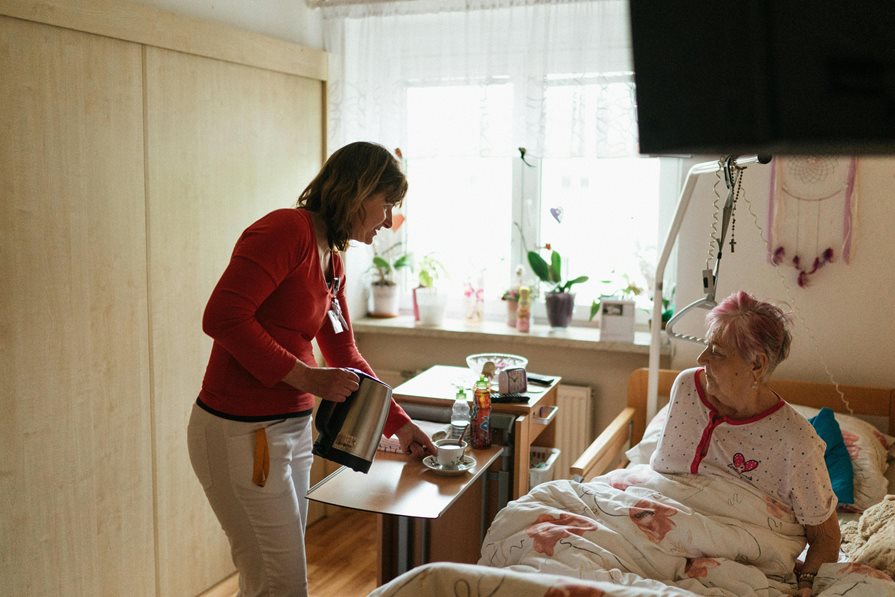 A women visiting a senior in a hospital bed