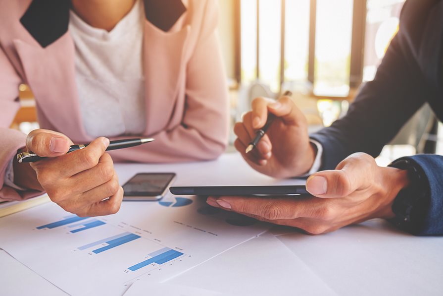 Two people using a tablet device for accounting Two people using a tablet device for accounting