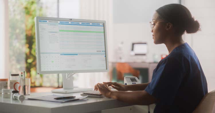 Female medical health professional working on a computer.