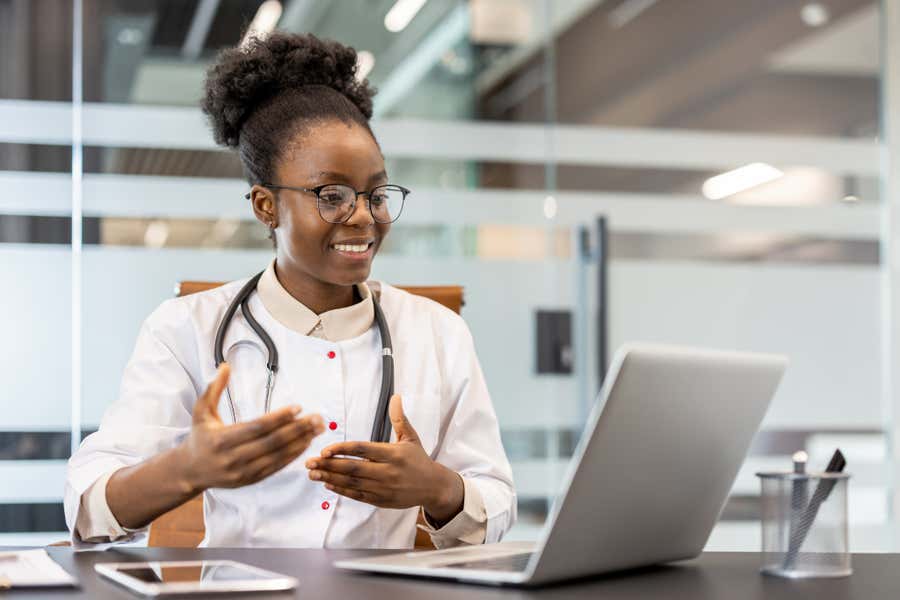Health care provider looking at a laptop.