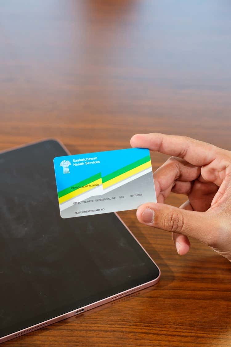 A hand holding a blank Saskatchewan health card.