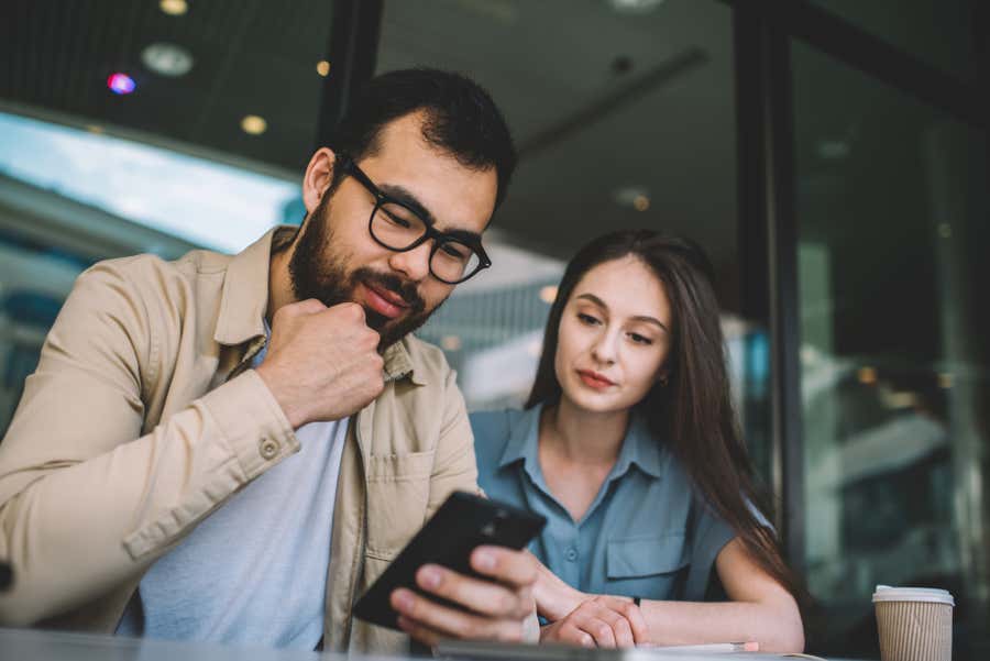 man and woman looking at a mobile device