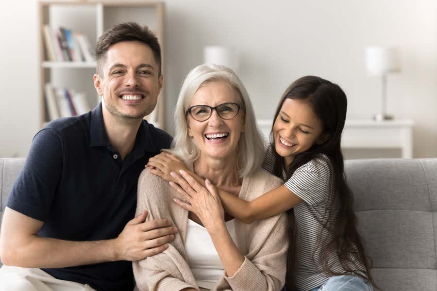 Family sitting together on a couch, smiling.