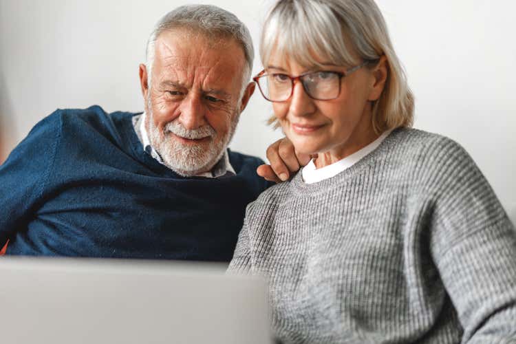 A man and women looking at a laptop.