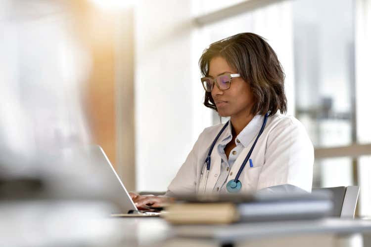 Female doctor working on a laptop.